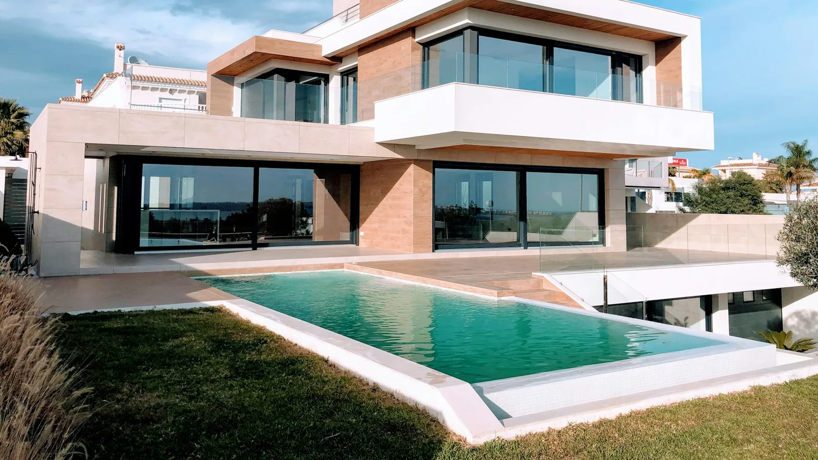 A modern white and brown home beneath a blue sky