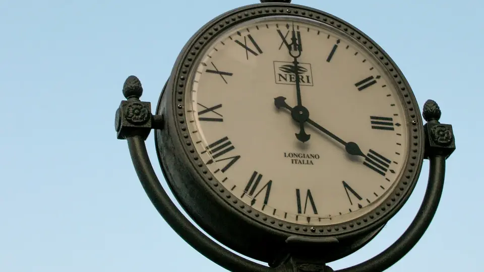 An outdoor clock with Roman numerals against the sky