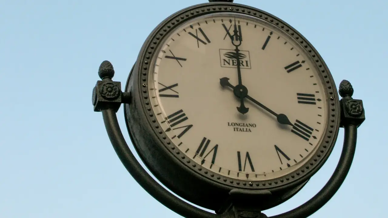 An outdoor clock with Roman numerals against the sky